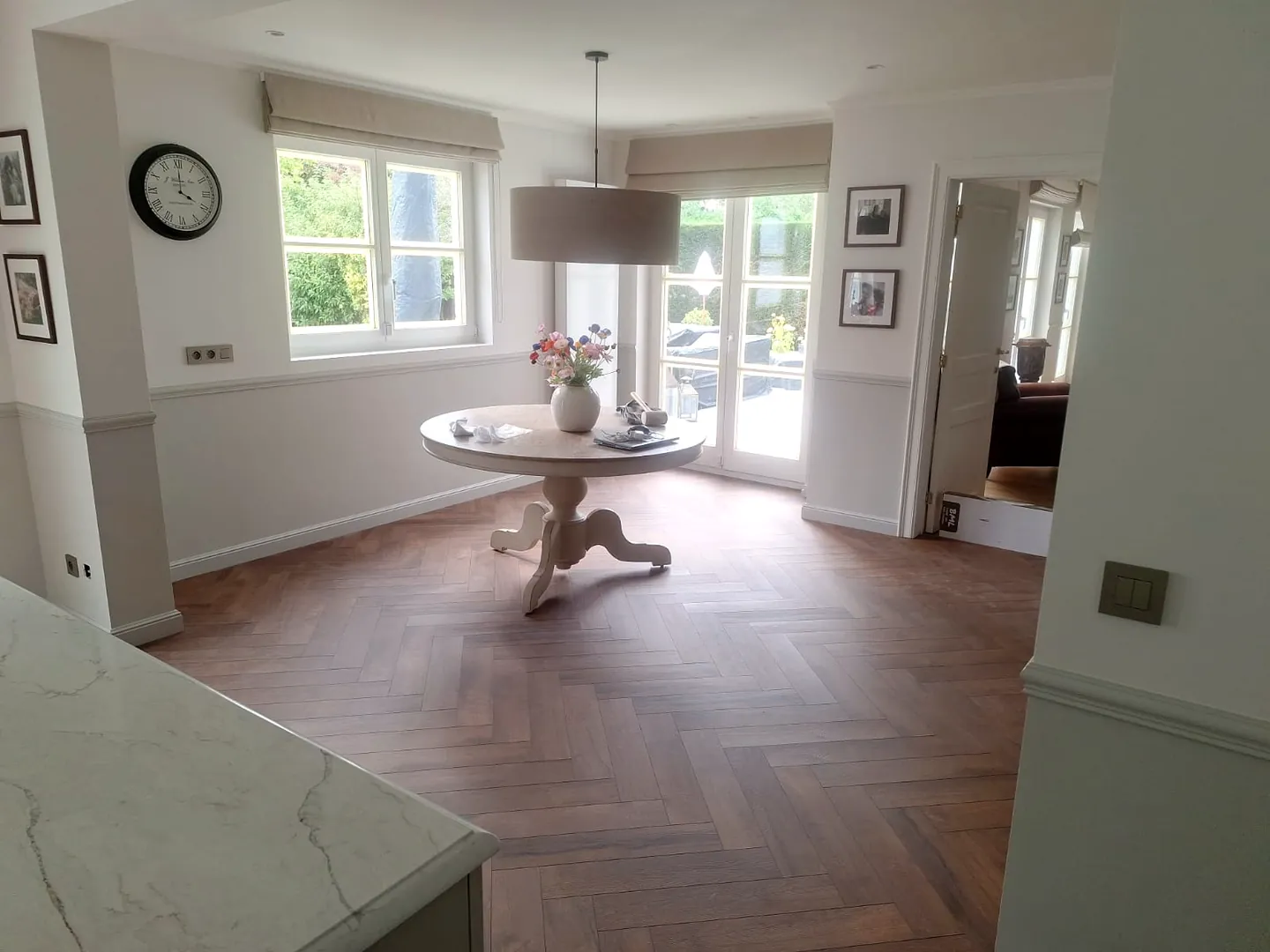 Parquet en chevrons à la teinte profonde dans une pièce aménagée, chantier Wood Floors en Belgique