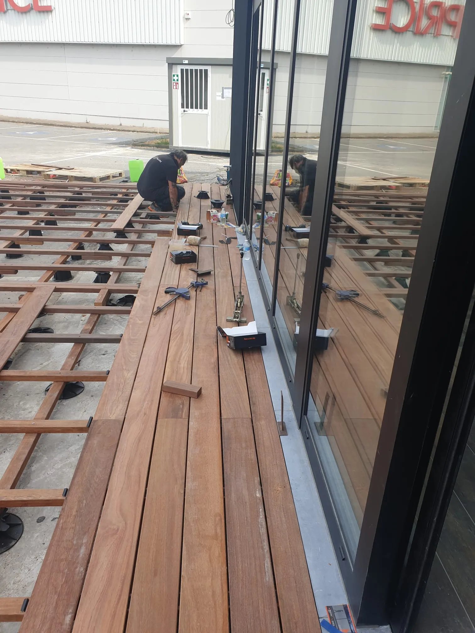Pose du platelage en bois exotique le long des vitrines, chantier Wood Floors