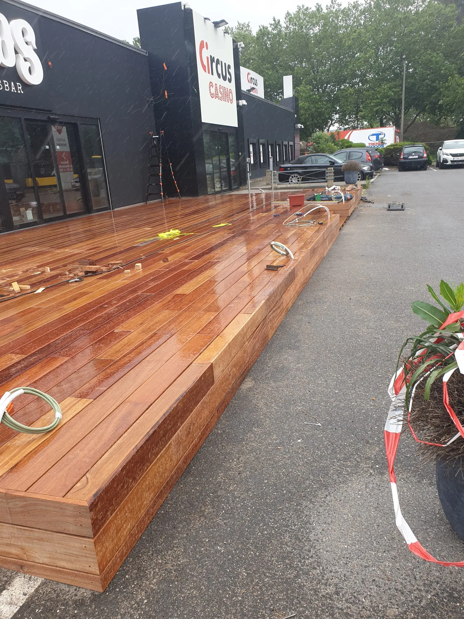 La terrasse commerciale sous la pluie, teinte profonde du bois exotique, chantier Wood Floors
