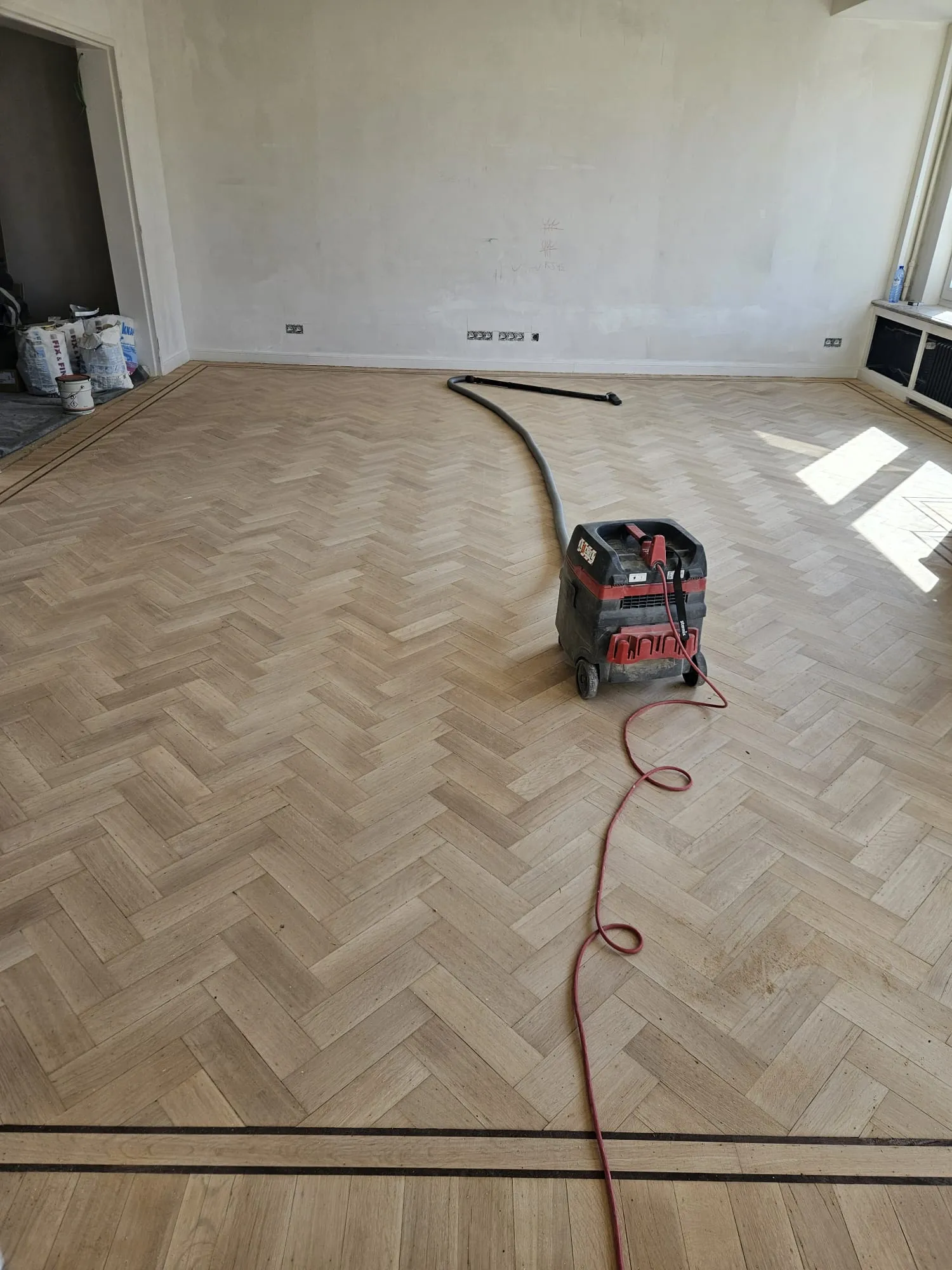 Parquet à joints perdus en cours de ponçage avec aspiration raccordée, chantier Wood Floors